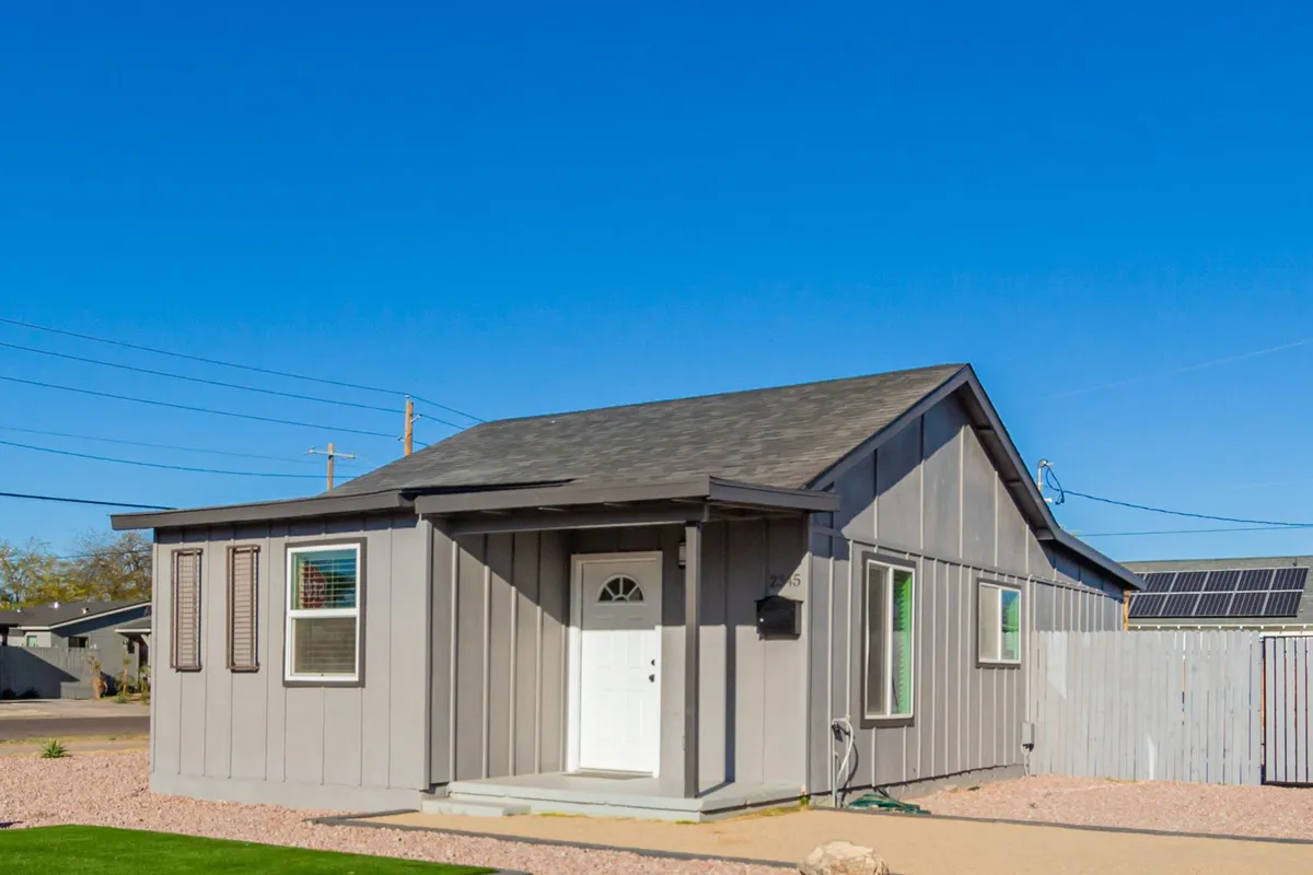 This bright exterior shot showcases the home’s welcoming front door, accented by charming window shutters and sunlit exterior walls. The scene evokes a sense of arrival and hints at the lively, family-friendly atmosphere found both at the property and in the neighborhood.