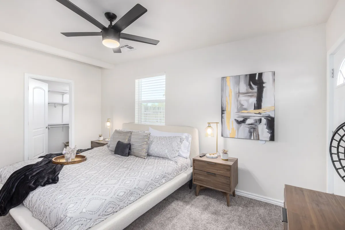 A serene bedroom with a cozy bed, nightstand, and stylish artwork. Sunlight streams through the window, creating an inviting atmosphere that hints at restful mornings and peaceful evenings. The space blends historic charm with modern comfort, suggesting a welcoming retreat after a day out in the city.